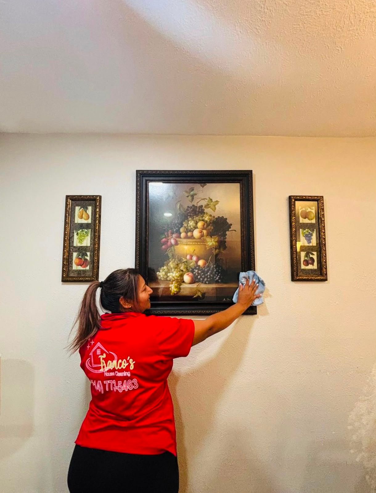 Franco’s team member cleaning wall decor